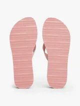 Ojotas de mujer con plataforma tipo cuña, base rosa con rayas verticales grises y entresuela blanca con borde dentado. Las tiras son de textil trenzado rosa con detalles brillantes.