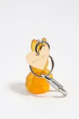 Llavero con dije de conejo de resina color naranja, argolla metálica y mosquetón plateado, acompañado de una placa metálica en forma de corazón.