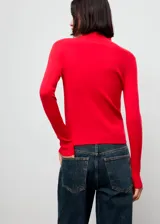 Jersey de punto fino color rojo, con cuello perkins, manga larga y diseño entallado.