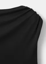 Vestido midi negro con diseño asimétrico, cuello redondo drapeado y detalle de frunces en el lateral. Falda de corte evasé con terminación en puntas.