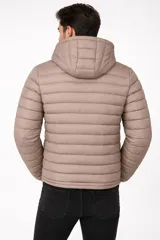 Campera puffer con capucha, cierre frontal completo y bolsillos laterales. Diseño acolchado de manga larga.