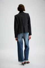 Blazer entallado con diseño peplum, confeccionado en tela con estampado de raya diplomática. Presenta cuello con solapas de muesca, cierre frontal con un botón, mangas largas y bolsillos delanteros con solapa.