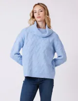 Buzo de punto grueso con textura en relieve, de cuello volcado y mangas largas con hombros caídos. Presenta puños y ruedo con terminación en rib.