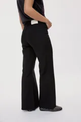 Pantalón de tiro medio y corte wide leg color beige, con diseño clásico de cinco bolsillos, presillas para cinto y cierre frontal con botón y cremallera.
