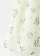 Top de tirantes finos en color beige con estampado floral pequeño y detalles de volados en los bordes. Cuenta con cierre frontal de cordones tipo lazo.