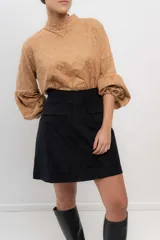 Minifalda negra de velvetine con spandex y bolsillos frontales.