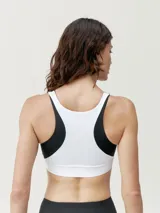 Top deportivo tricolor de sujeción alta, con tejido Shapplex_B efecto moldeador, diseño elegante combinando tres colores y logo en el pecho. Con copas fácilmente extraíbles.