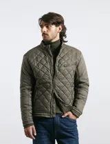 Campera capitoneada de color azul oscuro, con cierre frontal de metal y botones a presión. Presenta bolsillos laterales y en el pecho con cierres metálicos.
