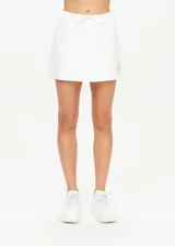 Short pollera blanco de algodón orgánico tejido con cintura con cordón y logo TU bordado en dorado en la parte delantera.