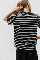 Remera de corte recto confeccionada en punto suave de algodón, con cuello redondo ribeteado y hombros ligeramente caídos.