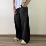 Pantalón jean de corte barrel, color azul clásico con efecto desgastado y diseño amplio y curvado en las piernas.