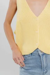 Chaleco celeste de punto con escote en V y cierre frontal con botones. Tejido calado y corte holgado.