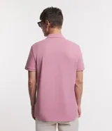 Remera polo de manga corta color verde militar, confeccionada en algodón peruano con cuello convencional y cierre de botones.