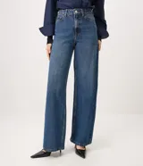 Pantalón wide leg de tiro alto confeccionado en jean de algodón, con pretina con pasacintos, cierre frontal con botón y cremallera, y bolsillos delanteros y traseros.