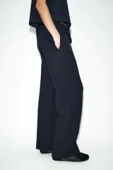 Pantalón de tiro medio confeccionado en tejido de punto elástico con pierna recta. Cuenta con cintura elástica ajustable mediante cordones y bolsillos laterales.
