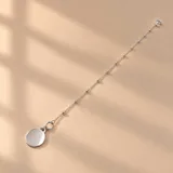 Pulsera de plata 925 con diseño de cadena con eslabones y pequeñas cuentas esféricas intercaladas, con dije colgante en forma de medalla circular lisa.