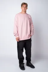 Buzo negro de corte oversize con cuello redondo y mangas largas. Presenta un pequeño logo estampado en el pecho y un diseño de empanadas y textos en la manga.