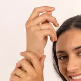 Anillo dorado con piedras tsavorita verdes y topacio blanco.