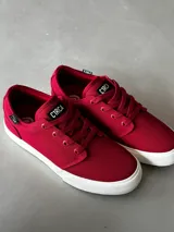 Championes de lona color bordó con suela blanca, de corte bajo y cierre con cordones.