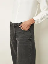 Jean de corte recto y tiro medio, confeccionado en denim de color azul clásico con costuras en contraste. Presenta diseño de cinco bolsillos y cierre frontal con botón y cremallera.