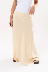 Pollera larga de corte recto en color amarillo pálido, con sutil textura en relieve y diseño fluido hasta los tobillos.