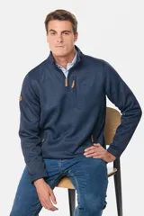 Buzo de felpa con interior polar, diseño de medio cierre frontal, bolsillos laterales y bolsillo vertical en el pecho con cierre. Presenta detalles en cuero sintético en los tiradores de los cierres y en la manga.