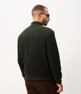 Campera bomber de hombre color verde oscuro, confeccionada en tejido polyvelour de textura aterciopelada. Presenta cuello, puños y cintura elastizados en ribana, cierre frontal oculto y bolsillos laterales.