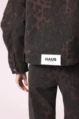 Campera de jean con estampado animal print en tonos marrones y negros, corte cropped y bolsillos delanteros.