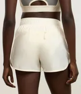 Bermuda deportiva Get Over modelo runner color beige, con cintura elástica, bajo redondeado y aberturas laterales. Cuenta con un pequeño bolsillo funcional trasero.