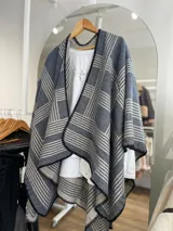 Ruana con diseño a rayas color gris y rosa, con borde de crochet negro.