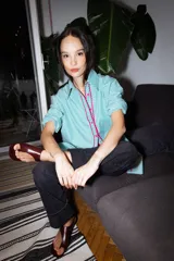 Camisa verde con rayas verticales blancas y detalles de zigzag rosa en el frente.