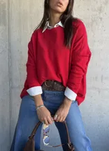 Sweater de tejido de punto en color rojo, con cuello redondo y mangas largas. Presenta un diseño holgado y cómodo.