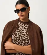 Remera de punto con estampado animal print de leopardo en tonos marrones y beige, de corte regular, cuello alto redondo contrastante y manga corta.