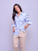 Camisa de vestir entallada a rayas verticales celestes y blancas, de manga larga y cuello clásico.