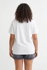 Remera color lila con estampa tipográfica marrón en el frente y mangas cortas.