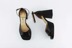 Sandalias de cuero negro con plataforma y tacón cuadrado. Tienen pulsera con hebilla al tobillo.