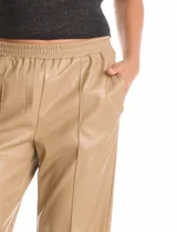 Pantalón de eco cuero negro con pretina elastizada, bolsillos laterales y pierna recta con costura frontal decorativa.