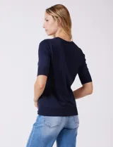 Buzo de tejido fino en color azul marino, con cuello redondo y mangas cortas con puños acanalados.