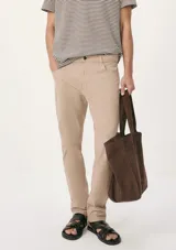 Pantalón recto negro con cierre de botón y cremallera, y bolsillos laterales.