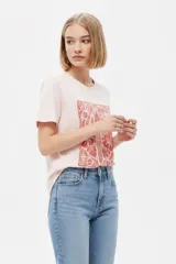 Remera de manga corta color azul con estampa frontal oscura de una ballena decorada con motivos florales.