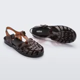 Sandalias Melissa modelo Possession, estilo pescador de color marrón translúcido. Confeccionadas en MelFlex vegano, cuentan con tiras entrelazadas, cierre lateral con hebilla ajustable y suela plana.