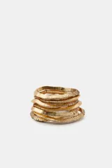 Set de seis pulseras elásticas doradas con apliques de piezas metálicas texturizadas.