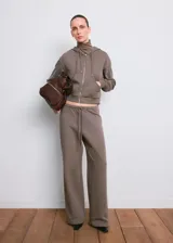 Campera con capucha y cierre frontal de cremallera, de color gris topo, con bolsillos canguro y diseño corto.