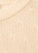 Jersey de punto calado color beige, con cuello redondo y diseño recto de manga larga.