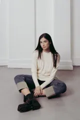 Sweater de punto con textura de ochos verticales, cuello redondo, mangas largas con puños acanalados y silueta relajada.