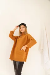 Sweater color ocre de lana de cordero con cuello alto abotonado y calce oversize.