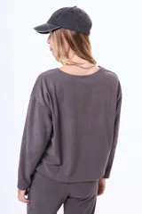 Buzo de felpa color beige con cuello redondo, mangas largas y costura central vertical en el frente.