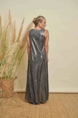 Vestido largo de corte amplio y línea simple, confeccionado en tejido de jersey con acabado metalizado plateado. Presenta cuello redondo y diseño sin mangas.