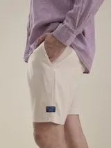 Bermuda de gabardina color beige, de corte casual y diseño liso, con bolsillos laterales y traseros.