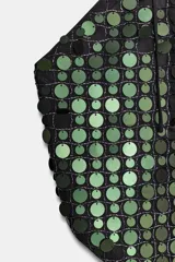 Top de cuello halter con diseño de rombo, cubierto completamente por lentejuelas circulares en tonos verdes y negros. Presenta un cierre con lazada ajustable en la parte superior y en la espalda.